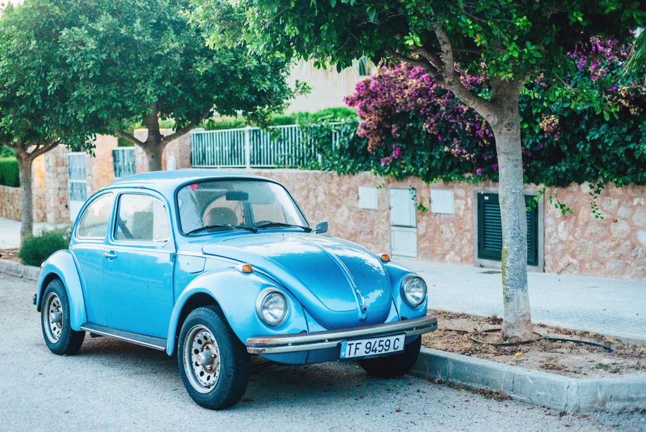Klasični plavi Volkswagen Buba pod drvećem